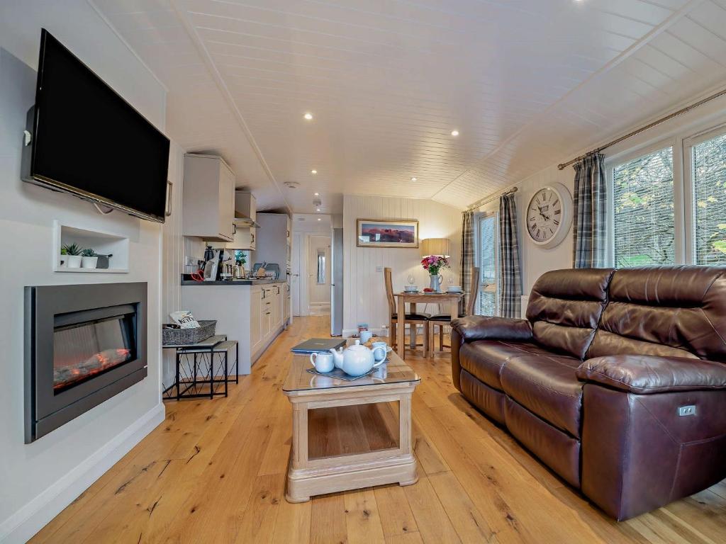 a living room with a leather couch and a fireplace at 1 Bed in Langbank 73846 in Langbank