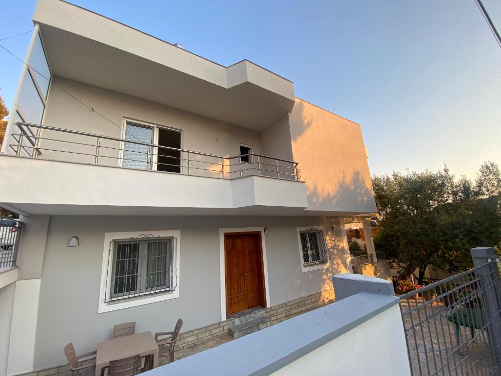 eine Villa mit einem Balkon vor einem Haus in der Unterkunft Hajdini Apartament & Studios in Sarandë