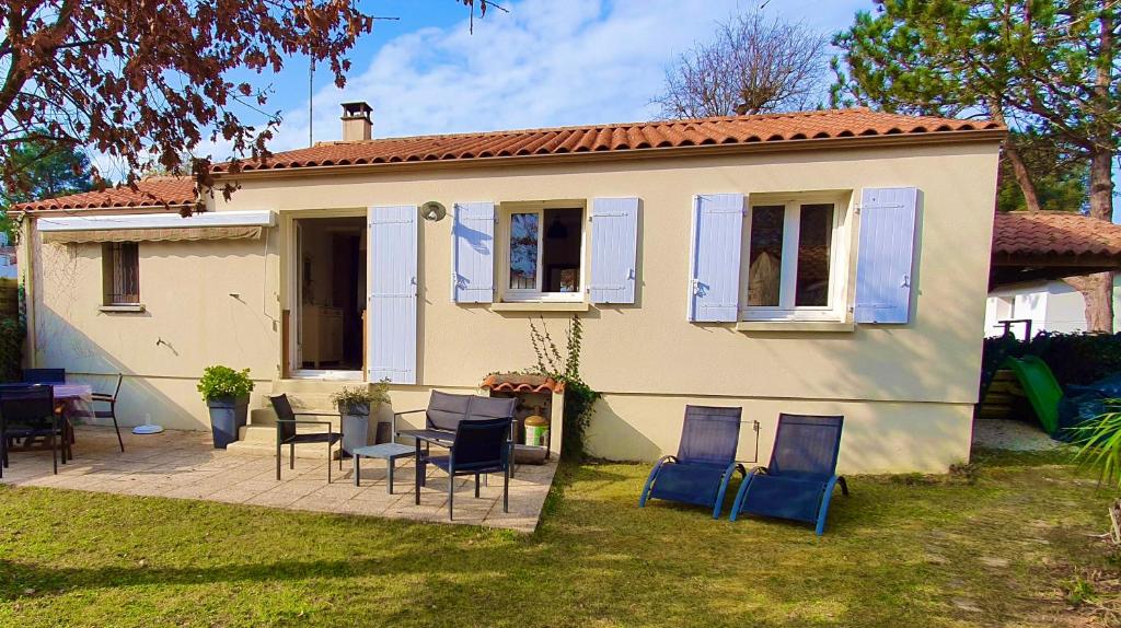 a house with chairs and a table in the yard at Tortuga in Dolus-d'Oléron