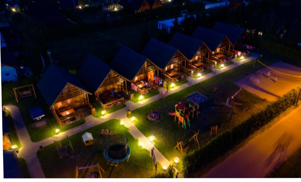 an aerial view of a resort at night with lights at Plażowa Domki in Mielenko