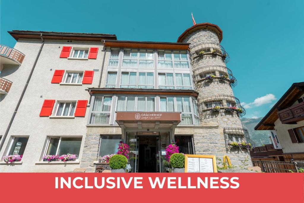 un edificio per il benessere inclusivo con le parole benessere inclusivo di Lifestyle & Spa Hotel Grächerhof a Grächen