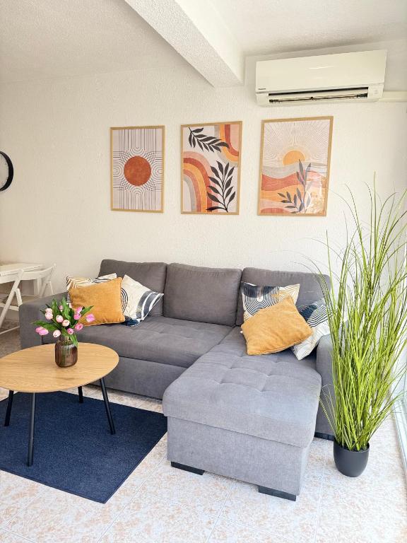 a living room with a gray couch and a table at Casa Salamanca La Mata in Torrevieja