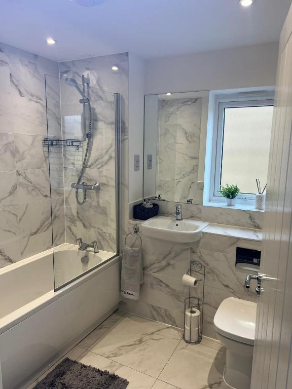 a bathroom with a shower and a sink and a toilet at Tranquility Home in Greenhithe