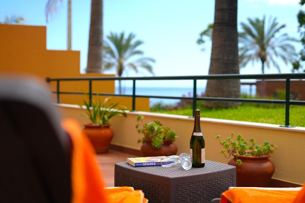 een fles wijn op een tafel op een balkon bij Madalena Sunset by Mill Escapes in Madalena do Mar