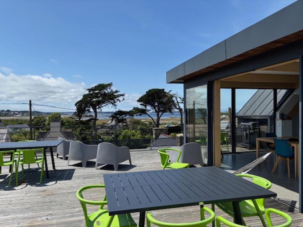d'une terrasse avec des chaises et des tables vertes. dans l'établissement Grande dune, Grande Dune Sea view rental in Port, à Penvénan