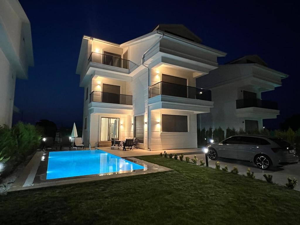 ein großes weißes Haus mit Swimmingpool in der Nacht in der Unterkunft Serentha Villas 2 in Belek