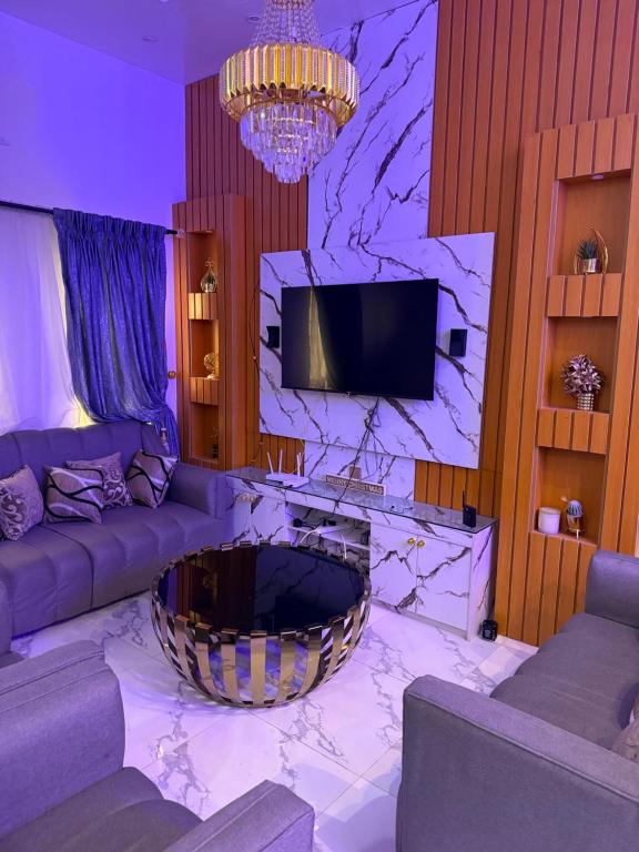 a living room with a couch and a tv at Comfortable stay at RCCG Camp Mowe 2 Bedroom Bungalow Retreat in Mowe