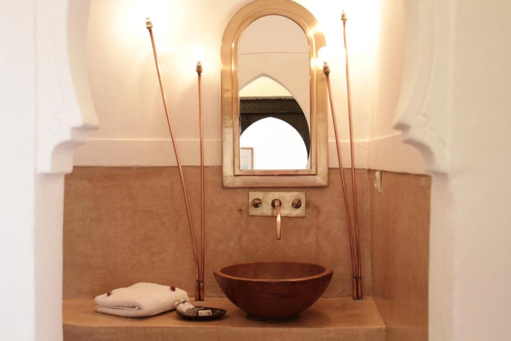 a bathroom with a bowl sink and a mirror at Dar El Qadi in Marrakech