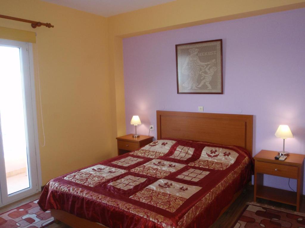 a bedroom with a bed and two lamps on two tables at Kate Apartments in Kokkari