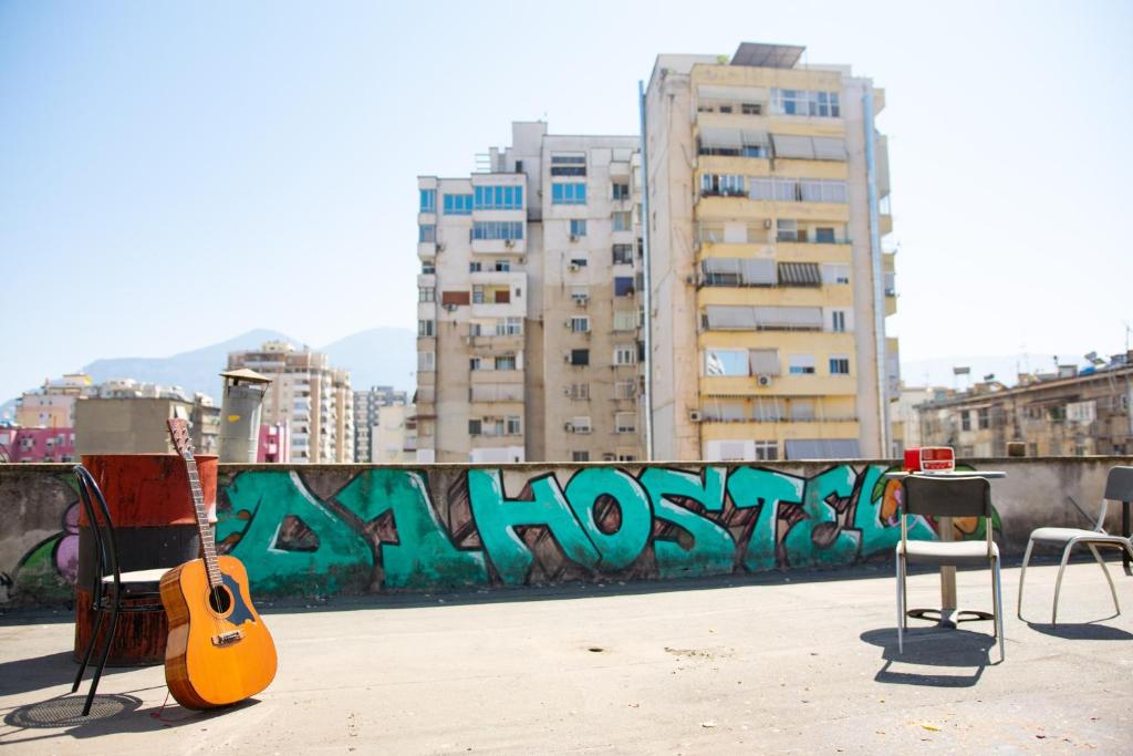 D1 Hostel في تيرانا: جيتار يجلس على حافة في مدينة