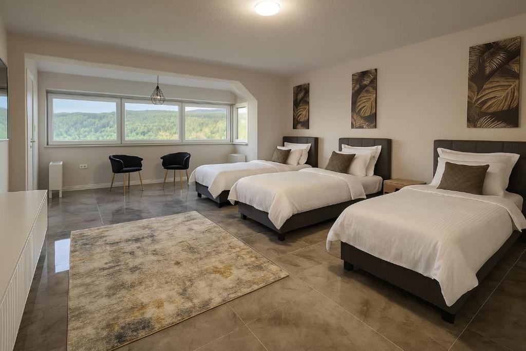 a bedroom with three beds and a table and chairs at Villa Sunrise Harmony near Sarajevo in Gladno Polje
