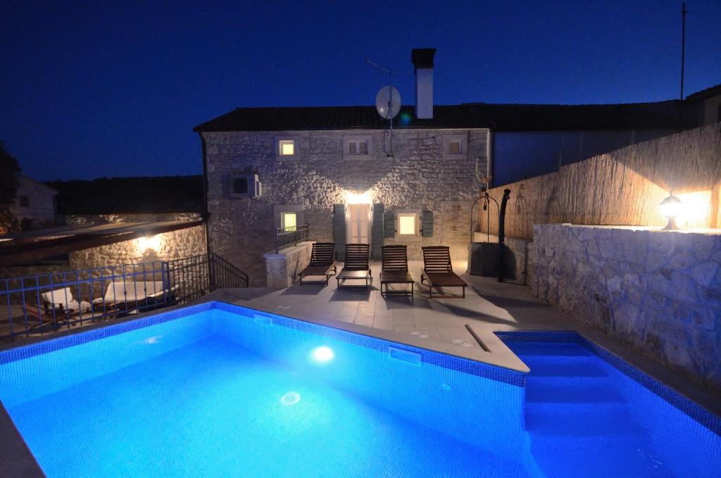 a swimming pool in front of a building at night at Villa Zonti in Rovinjsko Selo