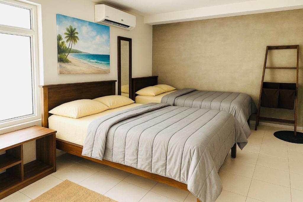 a bedroom with two beds and a picture of the beach at Lima Blue Private Beach Apartment in Trincomalee