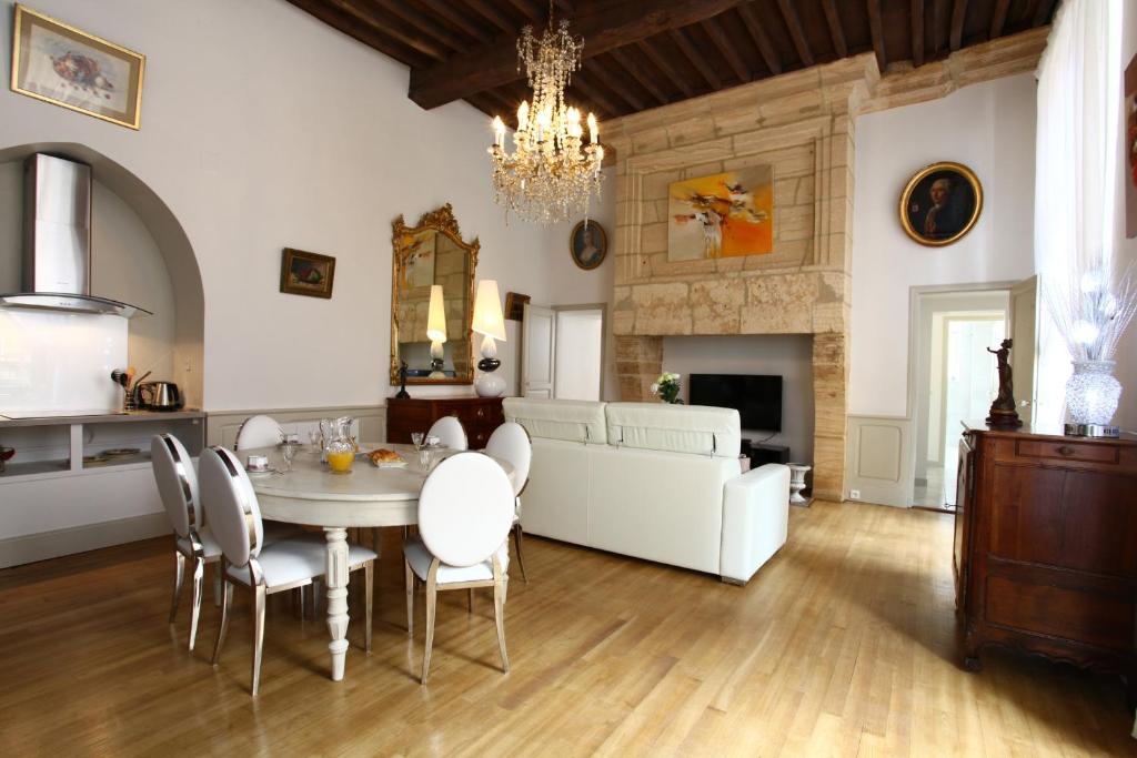 a living room with a table and chairs and a couch at Le Royere in Sarlat-la-Canéda