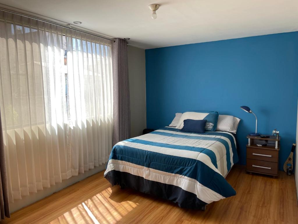 une chambre bleue avec un lit et une fenêtre dans l'établissement The Chill Spot, à Arequipa