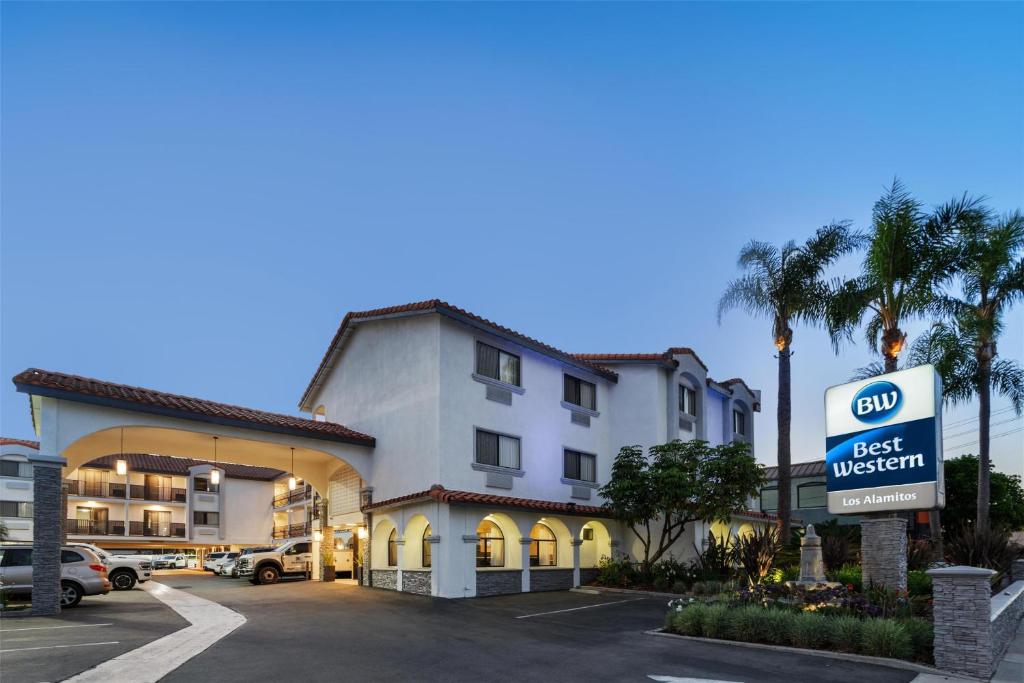 a hotel with a best western sign in a parking lot at Best Western Los Alamitos Inn & Suites in Los Alamitos