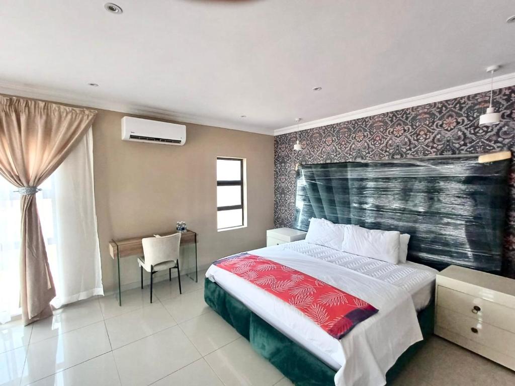 una camera da letto con un letto, un tavolo e una finestra di Hlako Lodge a Ga-Tisana