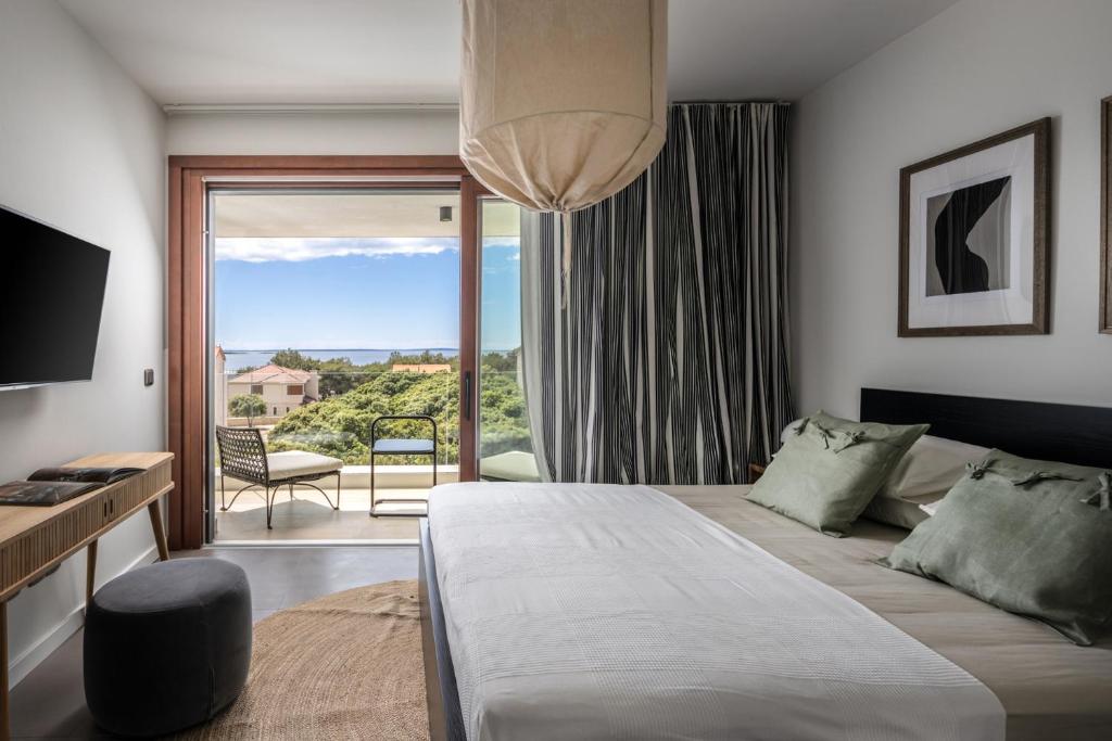 a bedroom with a large bed and a large window at Vila Oliva i Terakota in Mandre