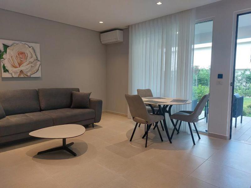 ein Wohnzimmer mit einer Couch und einem Tisch und Stühlen in der Unterkunft Blue Harmony in Lalzit Bay