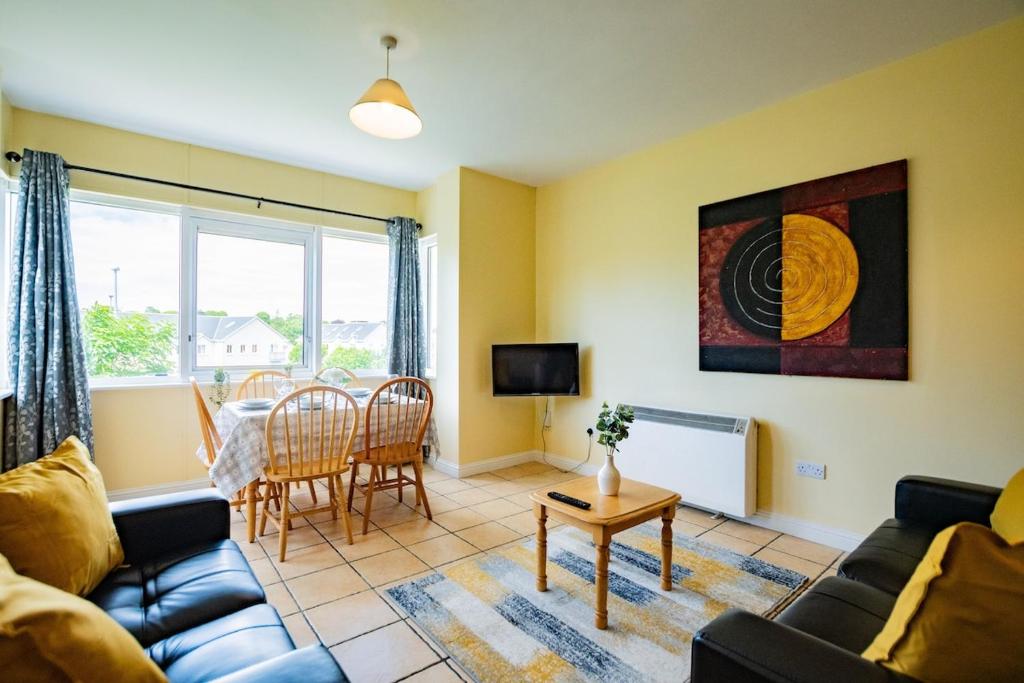 un salon avec un canapé et une table dans l'établissement Spacious & Affordable 3 Bed Apt, à Galway