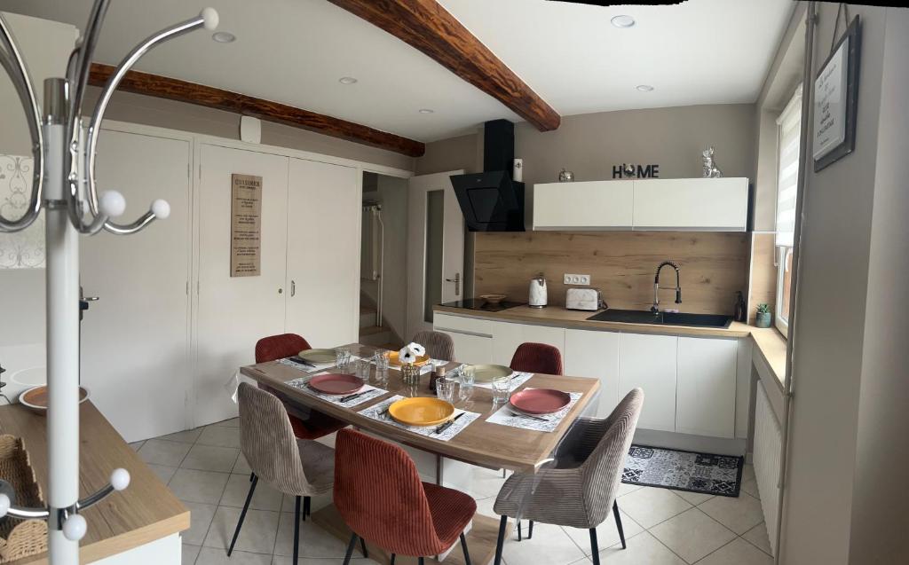 コロンビエ・ソニューにあるMaison 90m2 de 2 à 10 personnesのテーブルと椅子のあるキッチンとダイニングルーム