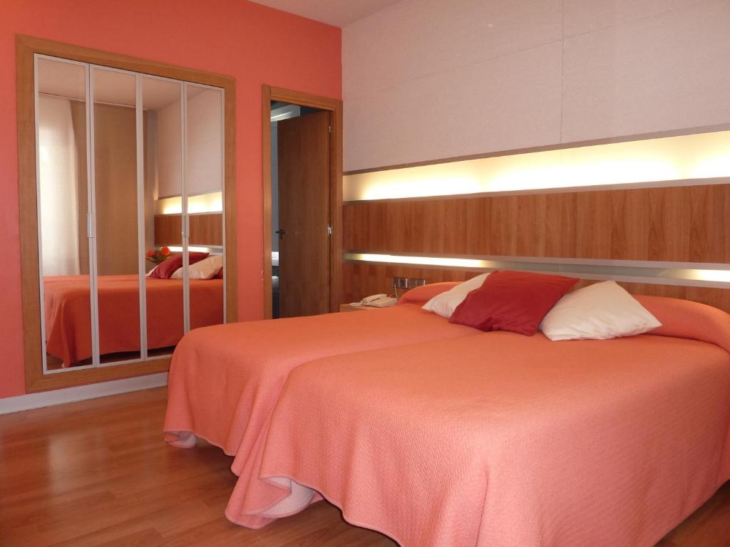 a bedroom with a large bed and a mirror at Hotel El Mesón in Javier