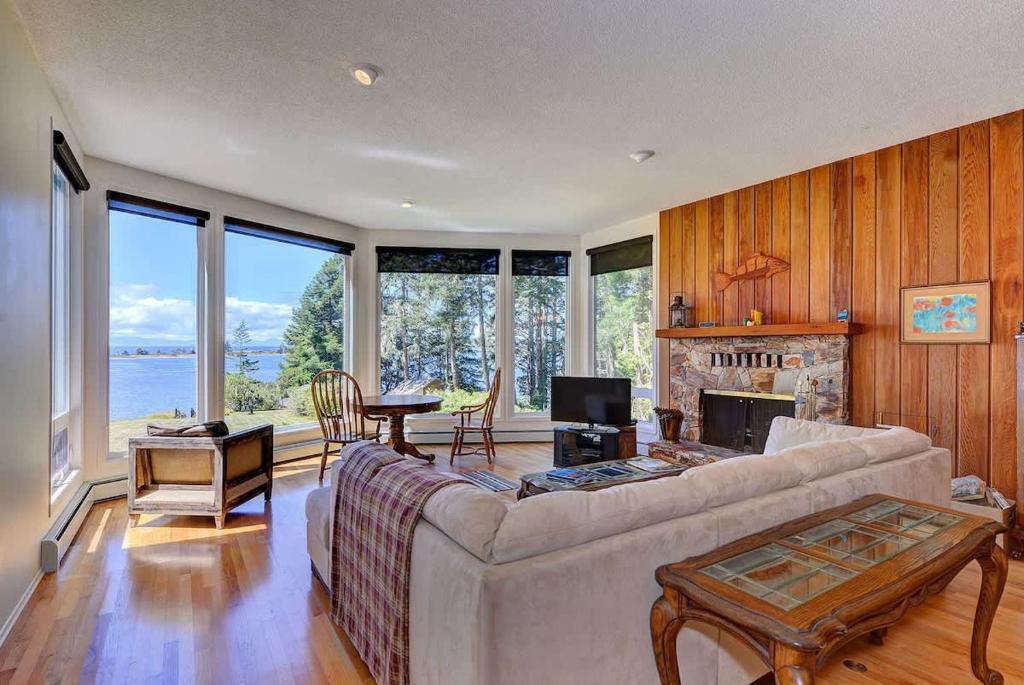 a living room with a couch and a fireplace at Pacific Coast Beach House by EMR Vacation Rentals in Sooke