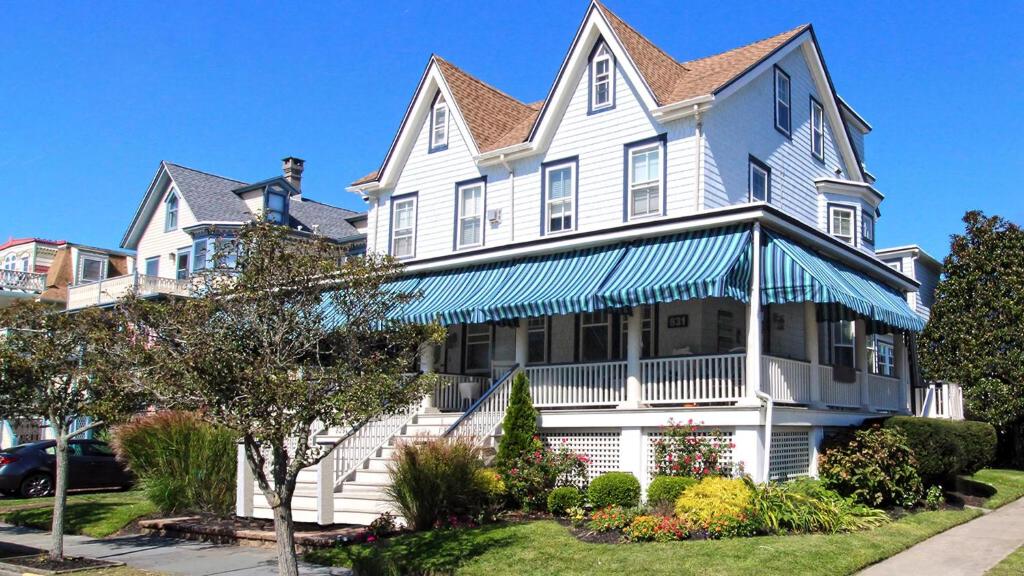 una gran casa blanca con toldo azul en Sand Castle, en Cape May