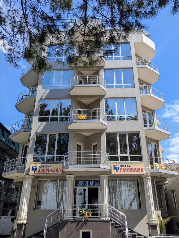 a tall white building with balconies on it at Panorama hotel kobuleti in Kobuleti
