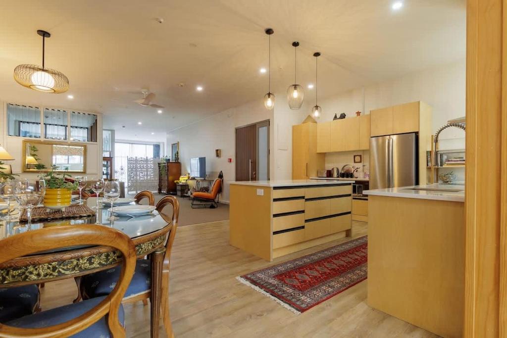 a large kitchen with a table and a counter top at Inn Tutanekai - Central City Chic 3 Bedroom 2 Bathroom Apartment in Rotorua