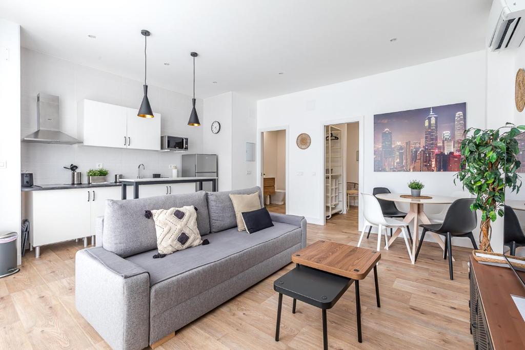 a living room and kitchen with a couch and a table at AB40 Home Design in Madrid