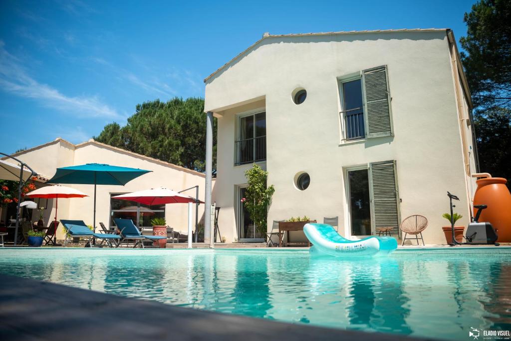 une piscine avec un gonflable bleu dans l'établissement La Villa Coucou, à Nîmes