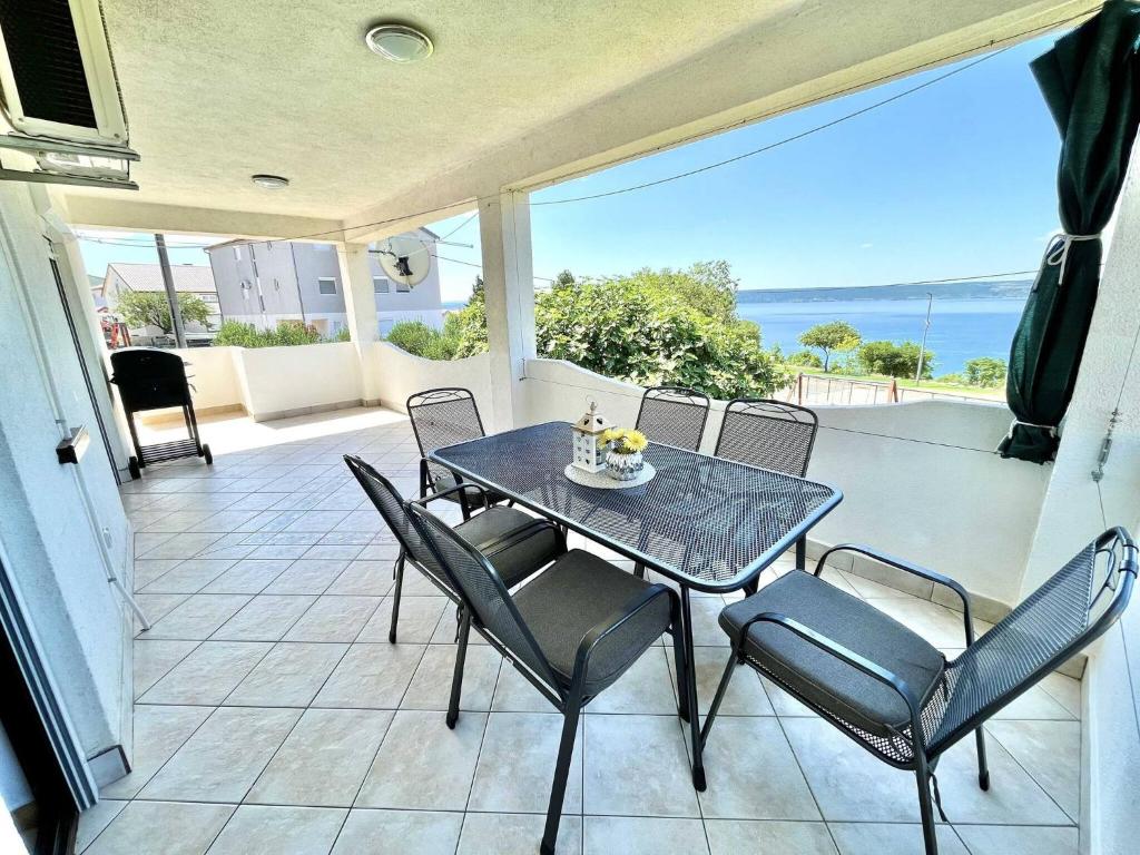 マスレニツァにあるMY DALMATIA - Holiday home Anatea with sea view terraceの海の見えるパティオのテーブルと椅子