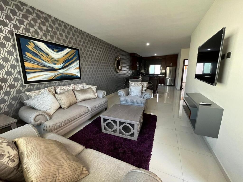 a living room with two couches and a tv at QB Departamento de lujo en Quintas espacioso y confortable in Culiacán