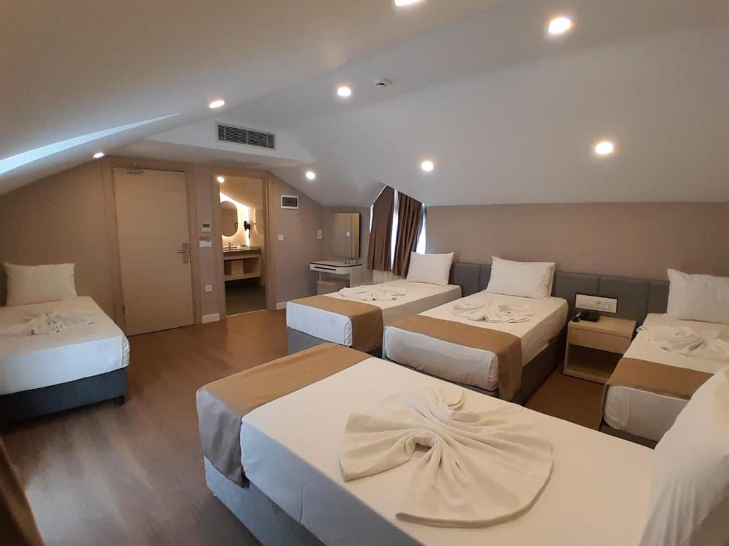 Una habitación de hotel con tres camas en una habitación. en Solis - Kumkapi, en Estambul