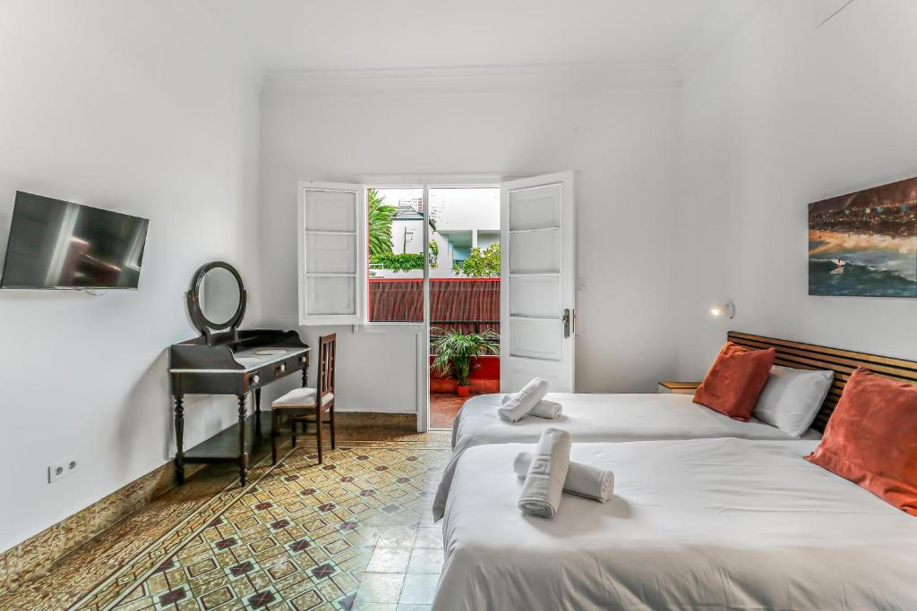 a hotel room with two beds and a desk at City Garden Suites Nadami 1935 in Las Palmas de Gran Canaria