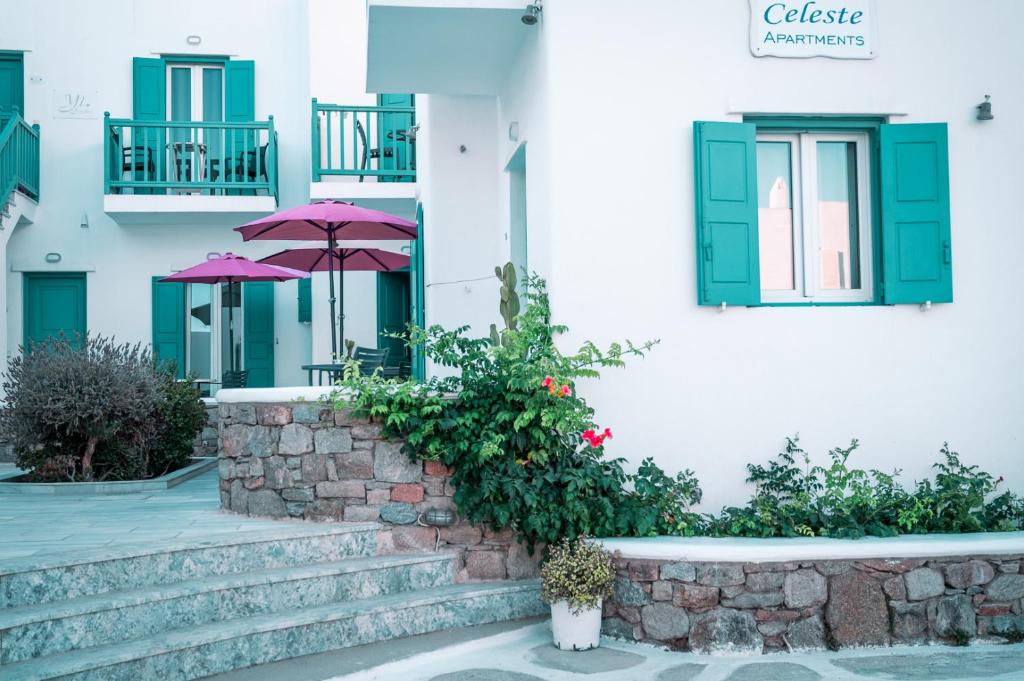 a building with a staircase and an umbrella at Celeste Apartments in Ornos