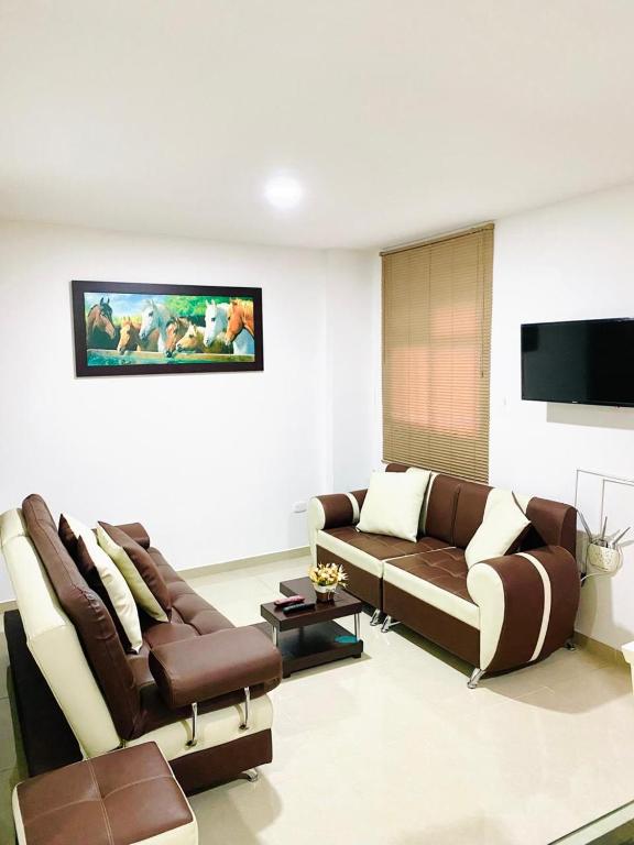 a living room with two couches and a flat screen tv at Santa Isabel Centro 302 in Santa Rosa de Cabal