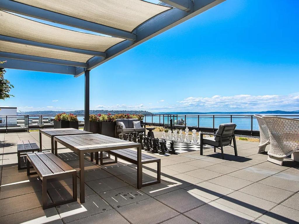 Un patio con mesas y sillas y vista al mar. en Luxury 1bedroom 1bath Space Needle, en Seattle