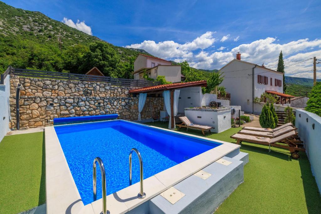 une villa avec une piscine et un jardin dans l'établissement House Bozica with sauna and pool, à Tribalj