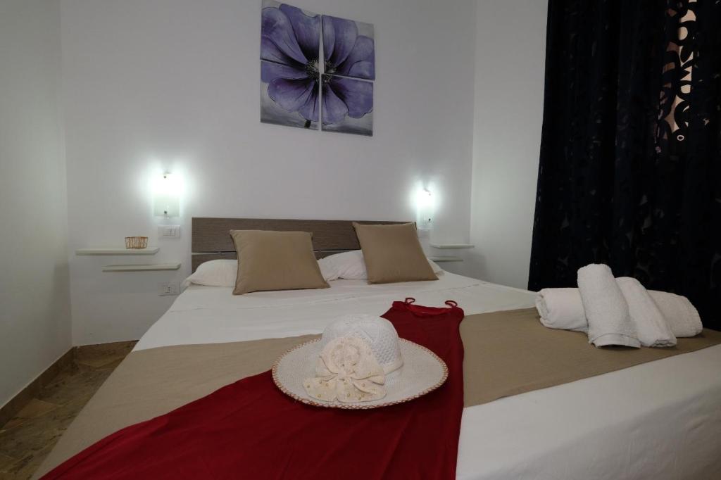 a bedroom with a bed with a hat on it at Villa Dolce Vita rooms in Castelluzzo