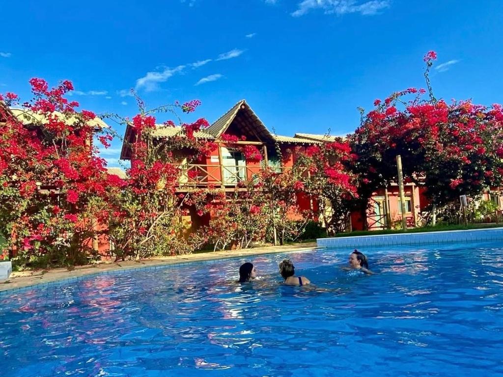 two people in the water in a swimming pool at Casa de Praia Chalé Luís Correia Piauí in Luis Correia