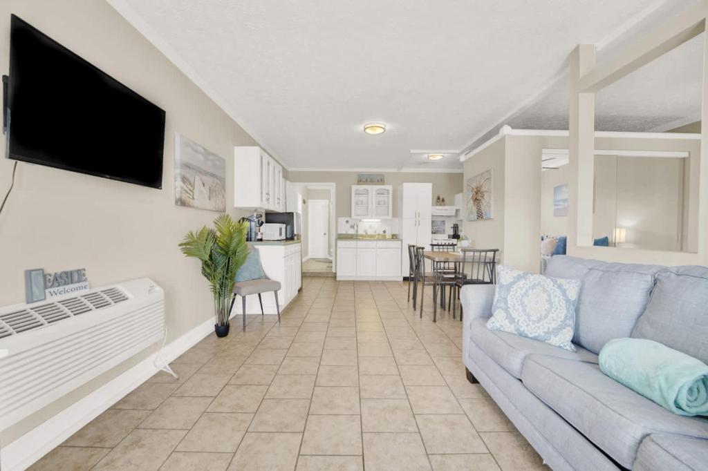 a living room with a couch and a kitchen at Luxe Guest Suite Near The Emerald Coast of PCB in Panama City
