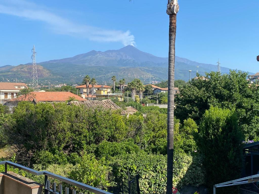 vista su una città con una montagna sullo sfondo di MMBook Casa Gebel Etna View ad Aci SantʼAntonio