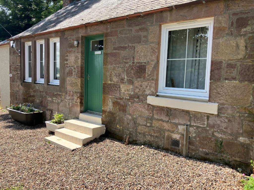 a brick house with a green door and a window at Wee Lyon Cottage Maybole 2 Bedroom Sleeps 4 in Maybole