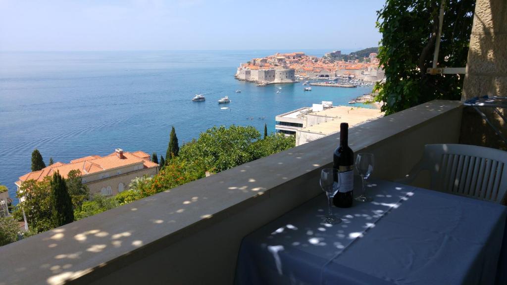 a bottle of wine sitting on a table with a view of the water at Nik 1 the Views Apartment in Dubrovnik