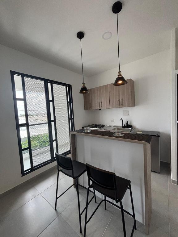 a kitchen with two chairs and a counter in a room at Urvan Studio in Montería
