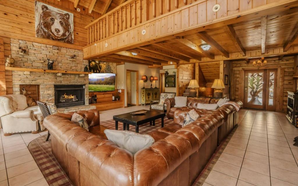 a large living room with a leather couch and a fireplace at Pop A Bear in Pittman Center