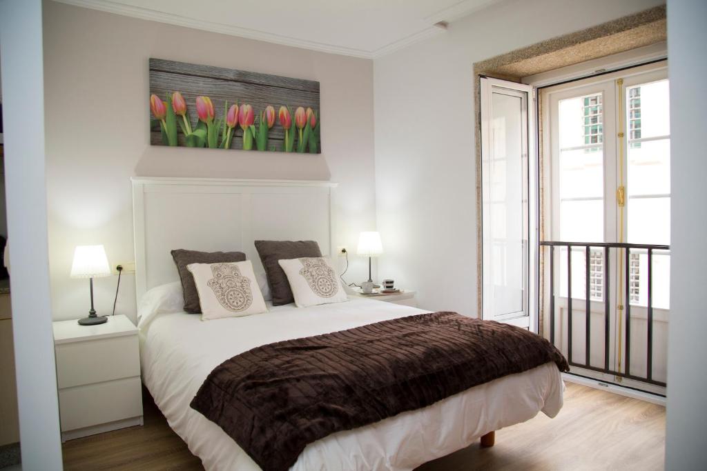 a bedroom with a bed with red tulips on the wall at Xavestre Rooms Santiago in Santiago de Compostela
