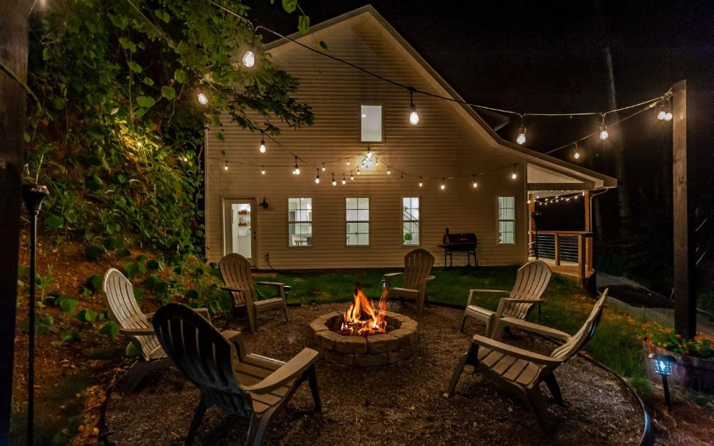 a backyard with chairs and a fire pit at night at Farmhouse in the Burg in Gatlinburg